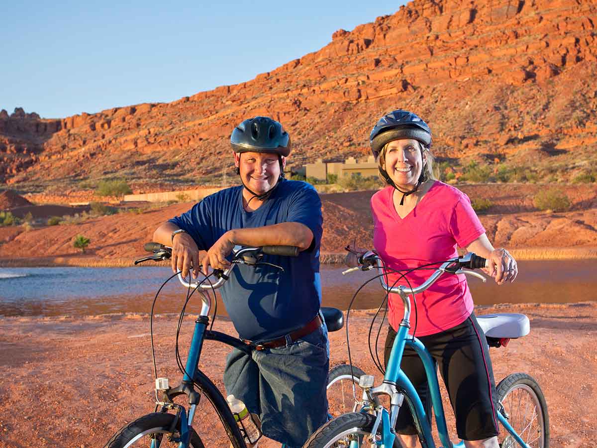 Adult couple riding bikes with helmets in Arizona for article Healthcare is Tops in Phoenix for newcomers moving to Phoenix.