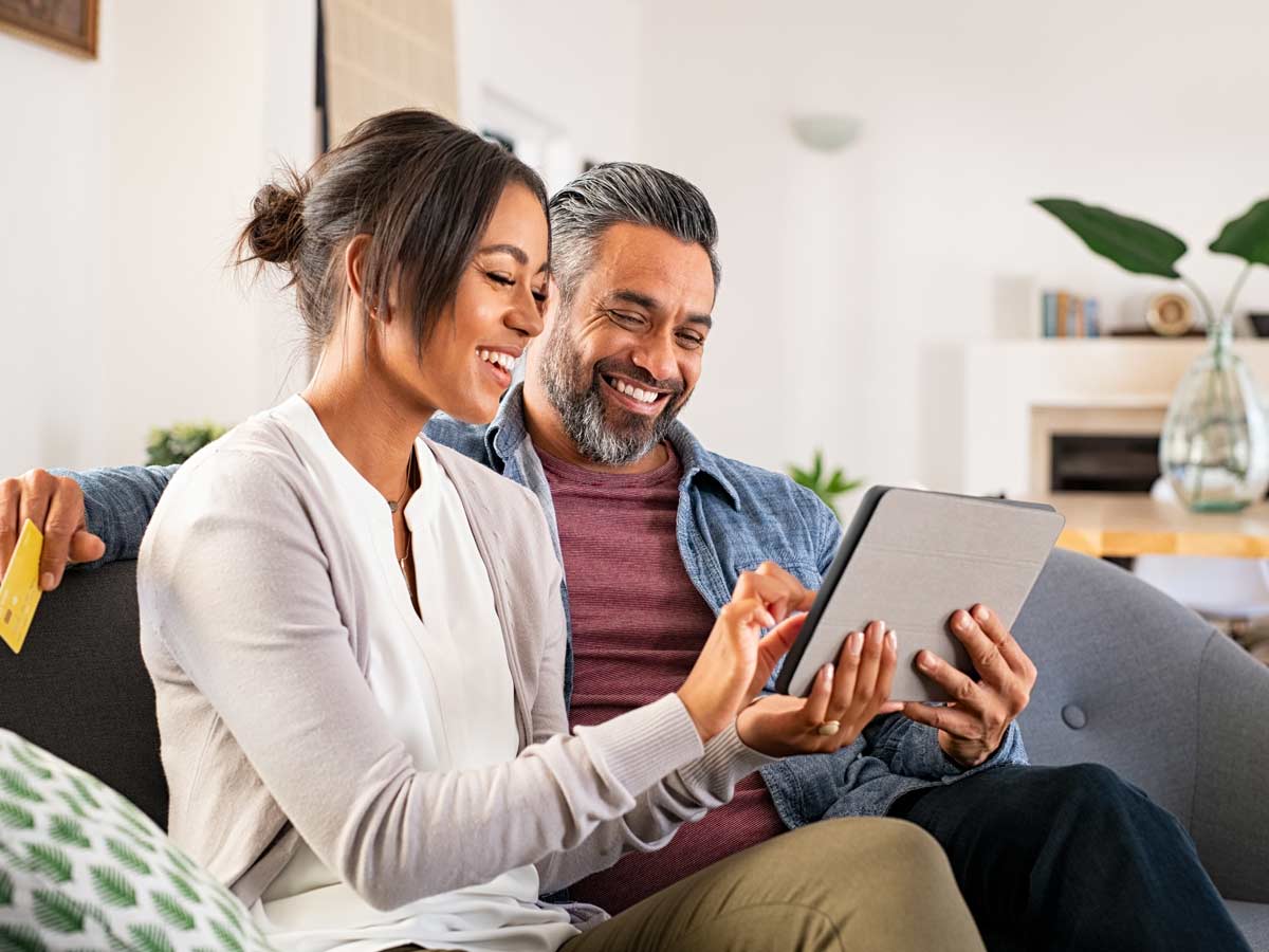 Couple looking at ipad for moving research for article Plan Your Move to Phoenix for newcomers moving to Phoenix.