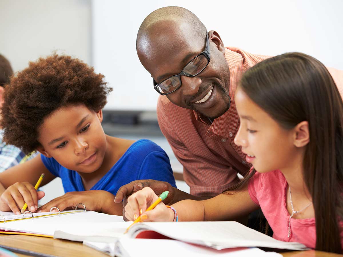 Teacher helping two students with their homework for article Phoenix School District Ratings for newcomers moving to Phoenix area.