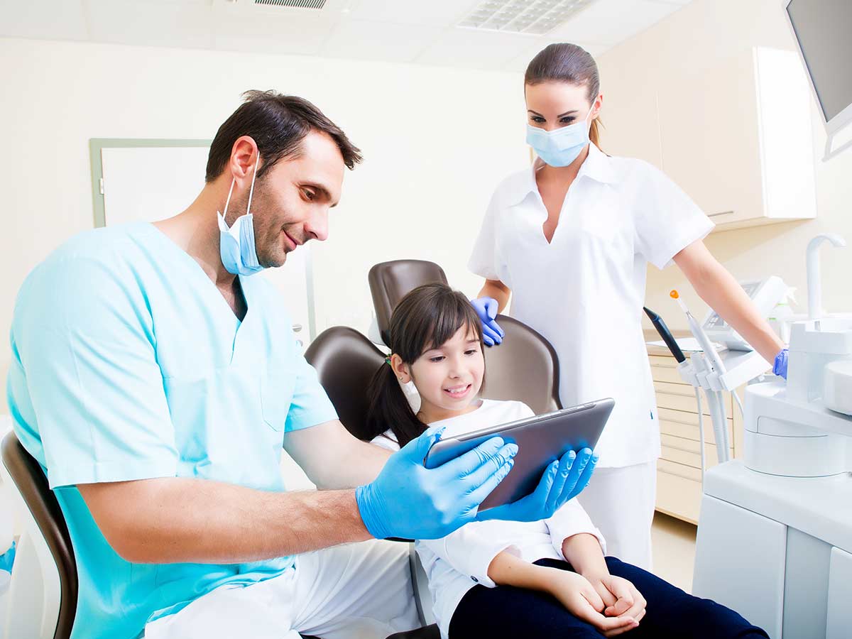 Dentist consulting young kid for article Choosing a Dentist in Phoenix for newcomers moving to Phoenix.