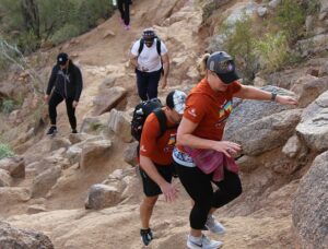 a group of people climbing a rocky trail, a sign of Growth in Phoenix