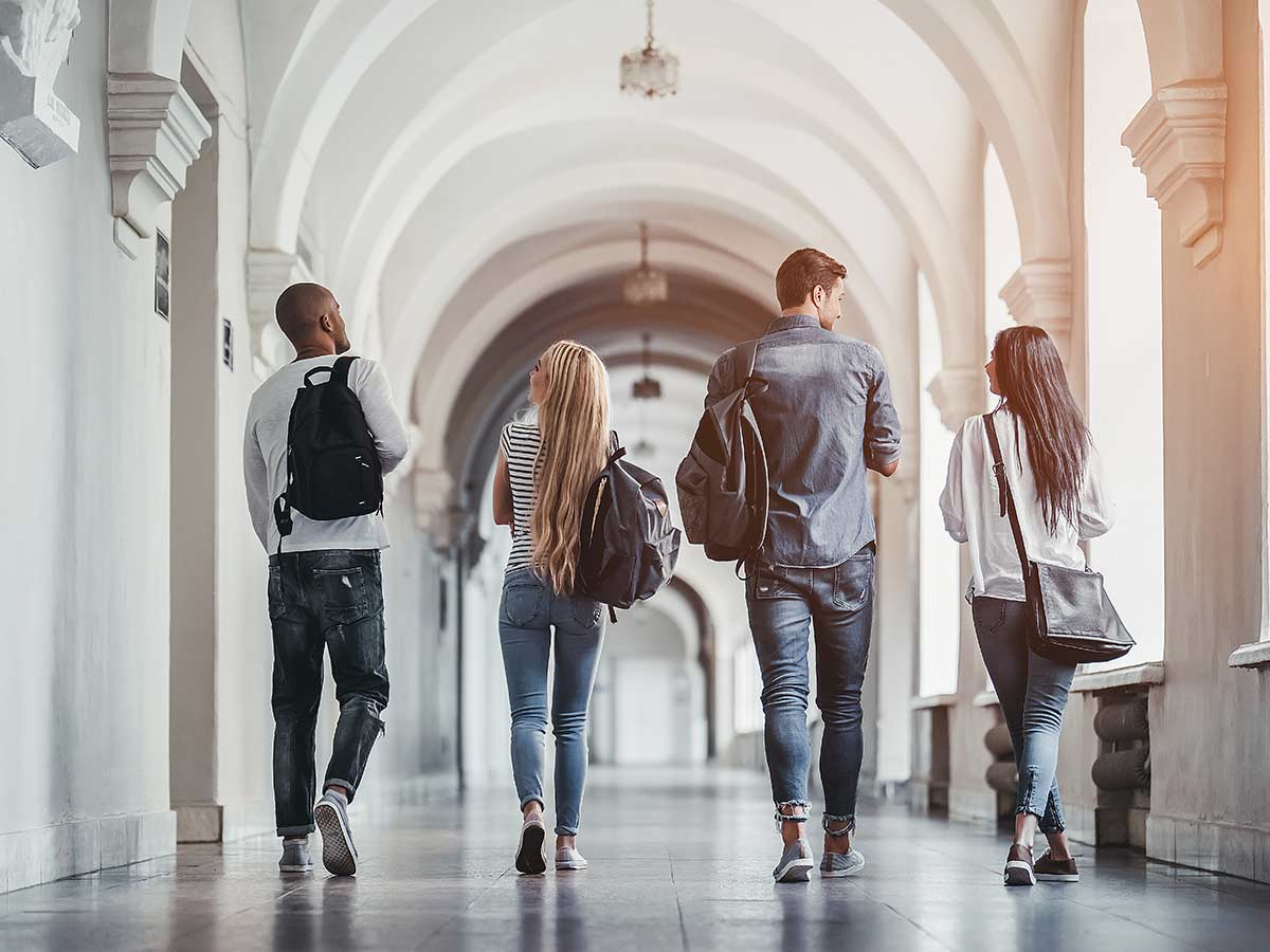 Four high school kids walking in a hallway with packpacks on their shoulders for article Top Private High Schools in Phoenix for newcomers moving to Phoenix area.