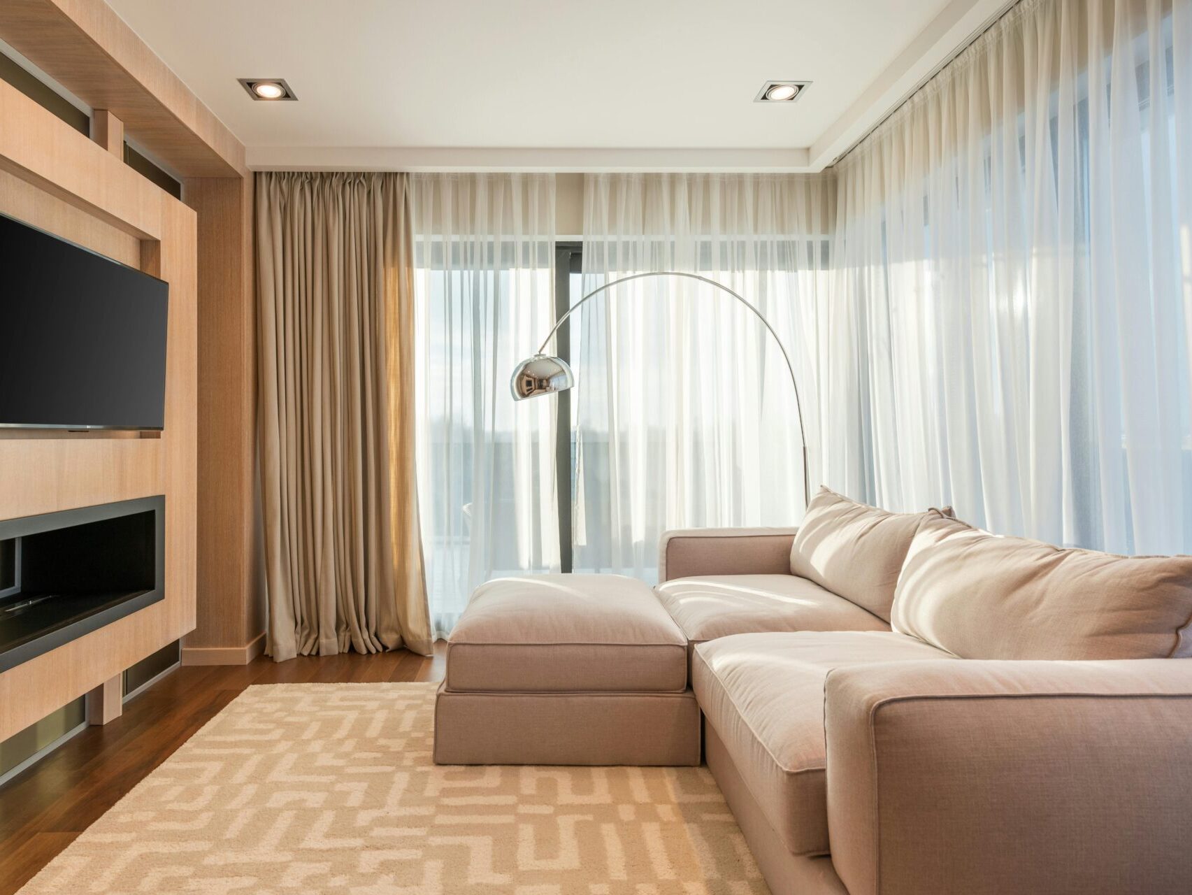 Interior of apartment with neutral colors and floor to ceiling curtains