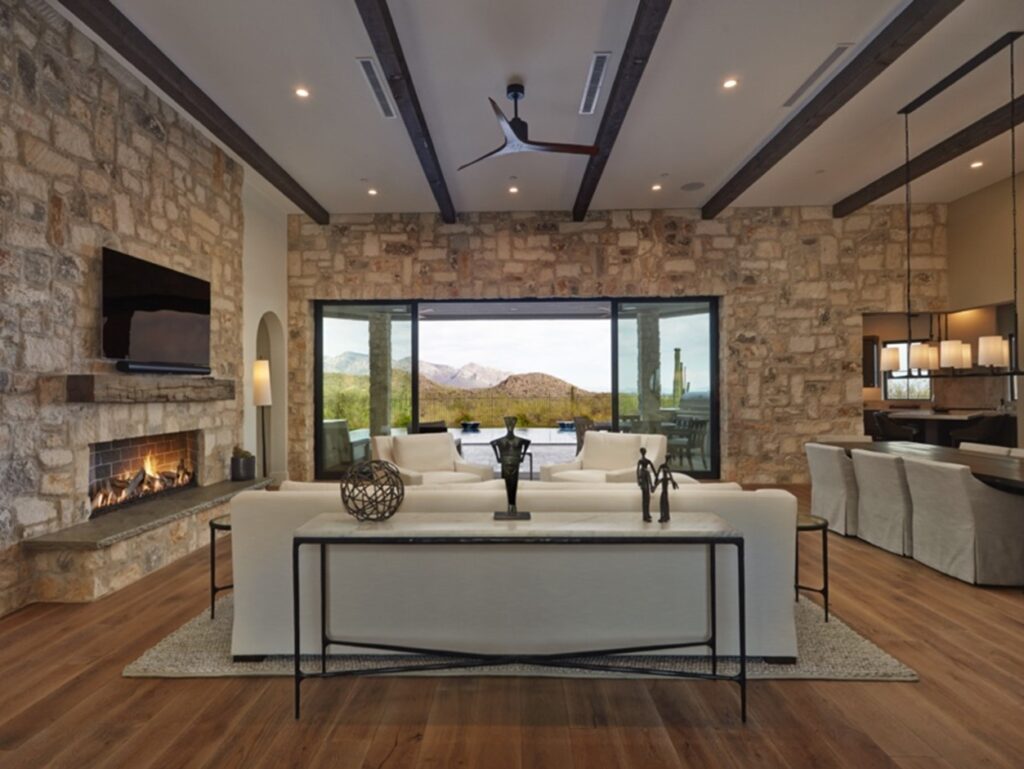 Inside shot of modern Dove Mountain home with mountains in the background outside the sliding glass doors.