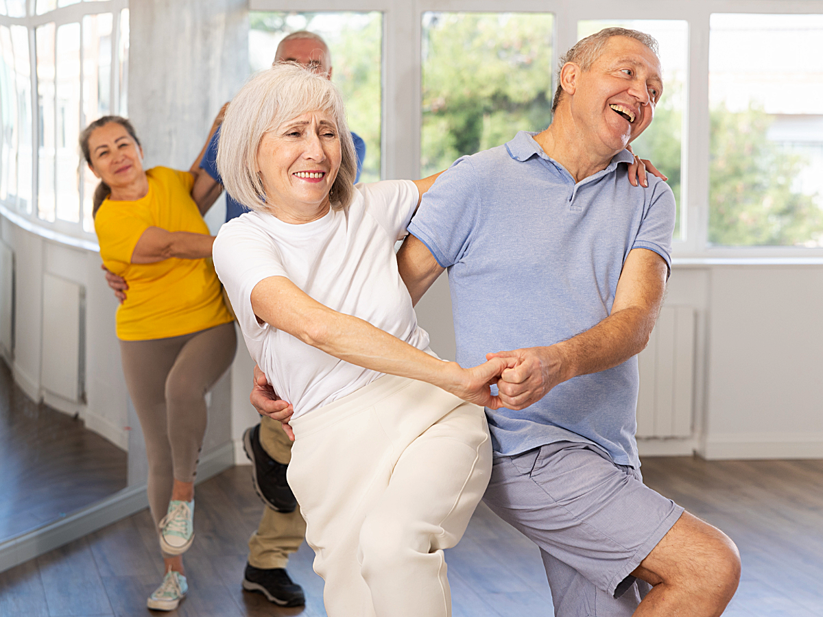 Seniors adults learning to dance in a class.