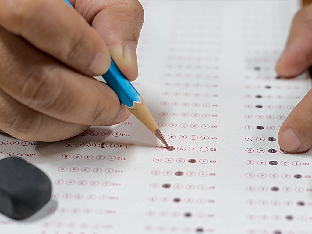 Person filling out standardized test.