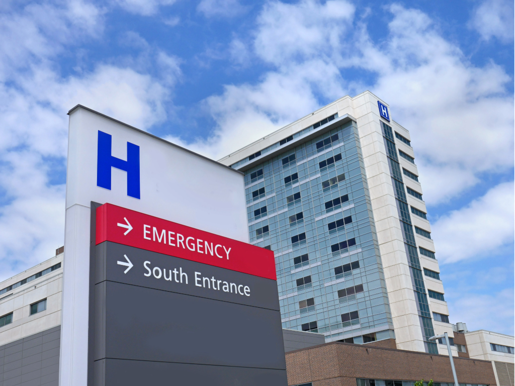 Outside picture of Hospital showing directional signage to emergency room.