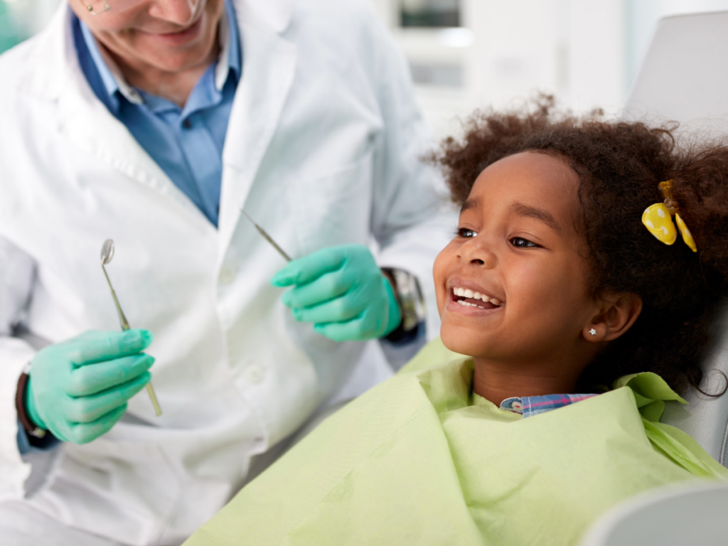 Young girl sitting in dentist chair smiling for article Discover 6 Trusted Dentists in Phoenix.