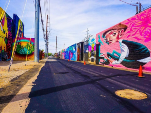 Looking down street with art murals painting on both sides for article Discovering the Most Unique Neighborhood in Phoenix for newcomers moving to Phoenix.