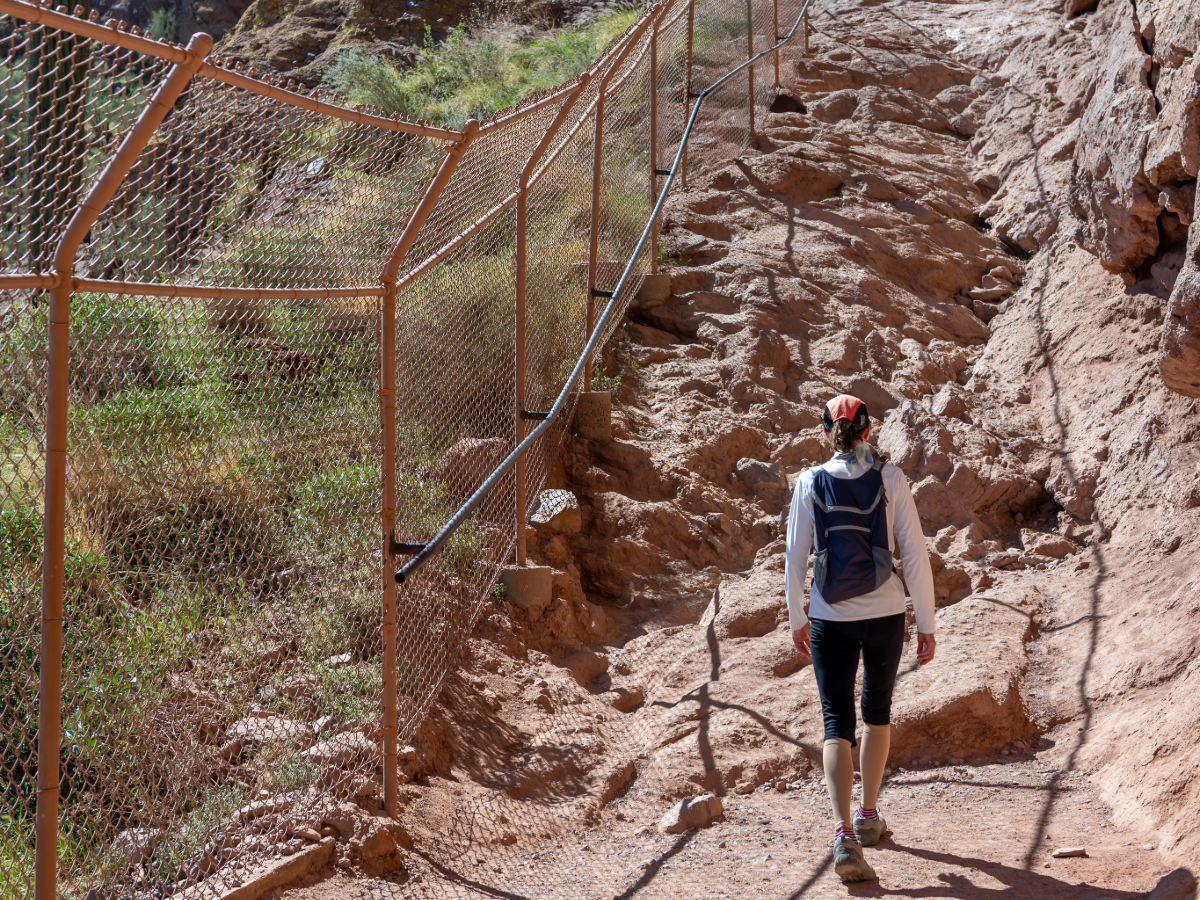 Person hiking up difficult terrain at Camelback Mountain in Phoenix for article 5 Unforgettable Outdoor Adventures in Phoenix for newcomers moving to Phoenix.