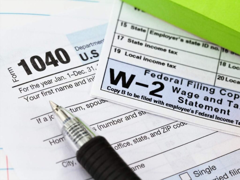 Close up of tax forms, W2, and a pen on top for article Navigating Arizona Taxes: A Guide for Newcomers