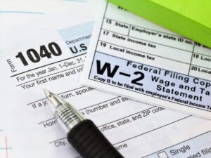 Close up of tax forms, W2, and a pen on top for article Navigating Arizona Taxes: A Guide for Newcomers