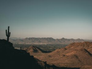 Living in the desert, a landscape of a desert with mountains and a city in the distance