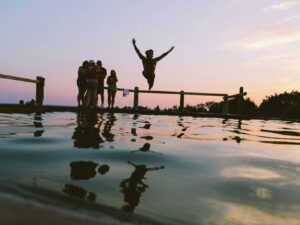 child jumping off a dock into a lake. Best Summer camps in Phoenix