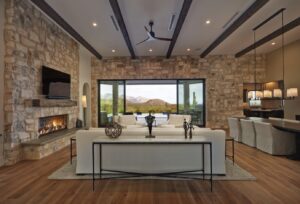 Inside shot of modern Dove Mountain home with mountains in the background outside the sliding glass doors.